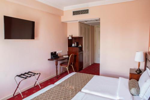 a hotel room with a bed and a desk at Hotel Pella in Giannitsa