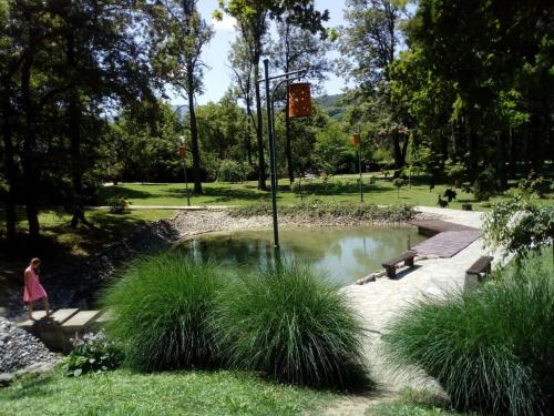 una ragazza che cammina intorno a uno stagno in un parco di Агни a Vrnjačka Banja