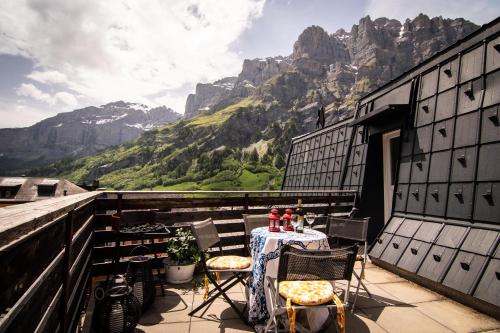 uma mesa e cadeiras numa varanda com montanhas em Weisses Rössli em Leukerbad