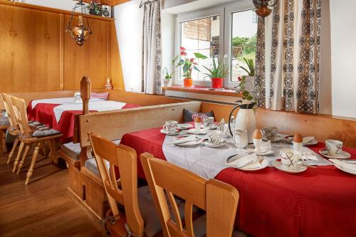 Un comedor con dos mesas con manteles rojos. en Haus Obermühle, en Maria Alm am Steinernen Meer