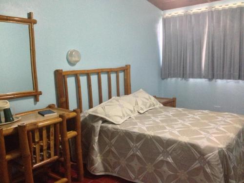 a bedroom with a bed and a table and a mirror at Hotel Caribe in Santa Cruz de Barahona