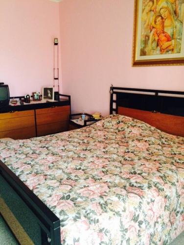 a bedroom with a bed with a floral bedspread at ALLEGROHOME your big nest in Barile