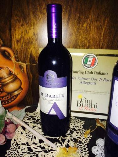 a bottle of wine sitting next to a box at ALLEGROHOME your big nest in Barile