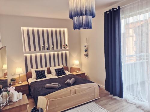 Schlafzimmer mit einem großen Bett und blauen Vorhängen in der Unterkunft Marine Apartament in Danzig