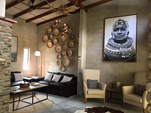 a living room with a couch and a large head on the wall at Dream of Africa Bush Lodge in Marloth Park