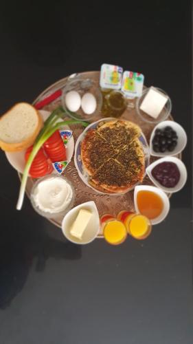a table with a plate of food and different foods at Panoramic View in ‘Isfiyā
