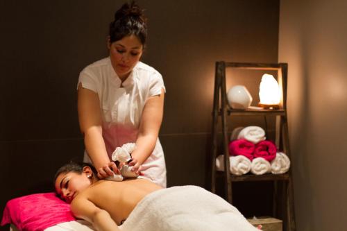 a woman is giving a man a massage at Golden Costa Salou - Adults Only 4* Sup in Salou