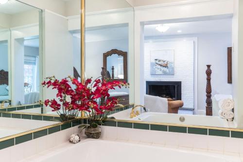 a bathroom with a tub and a large mirror at The Villa Bed and Breakfast in Westerly