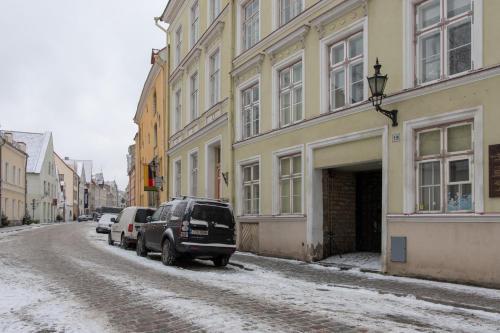 a snowy street with cars parked next to buildings at Exclusive Charm of the Old Tallinn in Tallinn