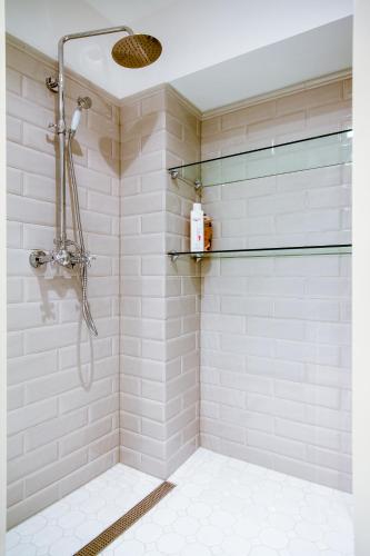 a bathroom with a shower with white tiles at Exclusive Charm of the Old Tallinn in Tallinn
