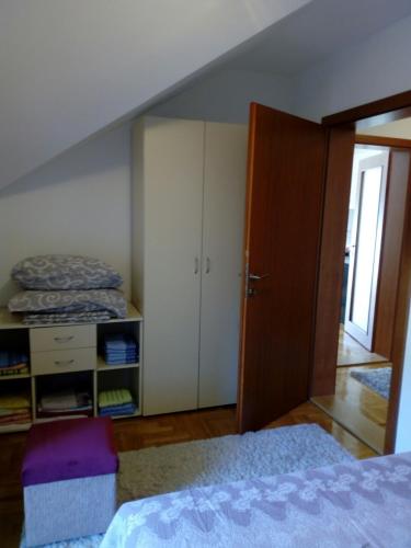 a bedroom with a bed and a closet and a door at Jasna Apartman in Vrnjačka Banja