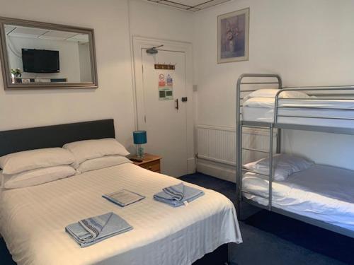a bedroom with two bunk beds and a mirror at The Mornington Hotel in Blackpool