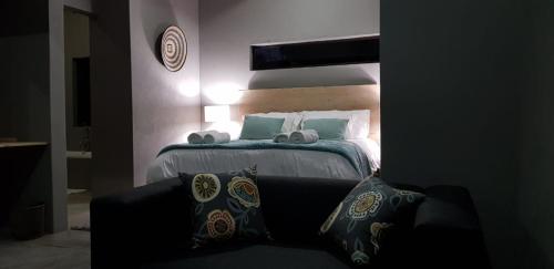 a bedroom with a bed with pillows and a couch at Dream of Africa Bush Lodge in Marloth Park
