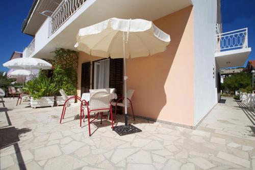 a patio with a table and chairs and an umbrella at Apartments Delic in Stari Grad