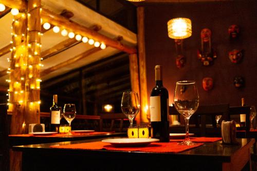 una mesa con botellas de vino y copas. en Casa de La Chola, en Ollantaytambo