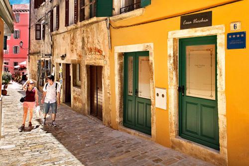two people walking down a street in an alley at Apartments Casa Vecchia in Rovinj