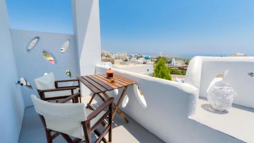 a balcony with a table and chairs and a view at Pasithea Suites in Megalokhori