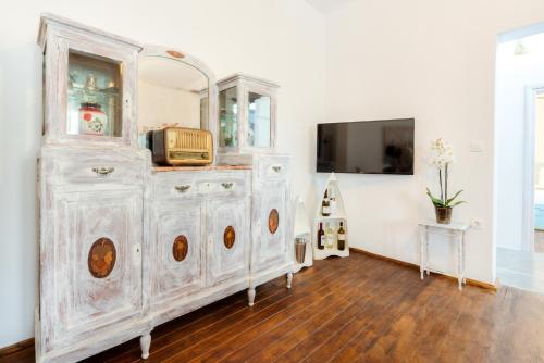 a white dresser with a mirror and a tv at Pasithea Suites in Megalokhori