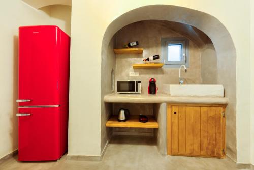 a kitchen with a red refrigerator and a sink at Pasithea Suites in Megalokhori