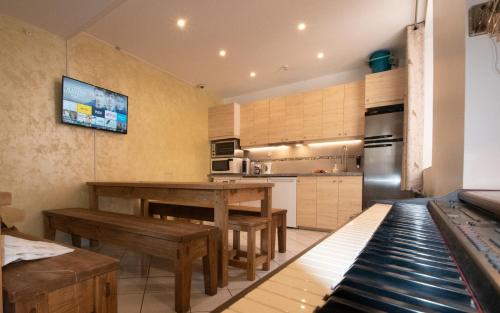 - une cuisine avec des tables et des bancs en bois dans une pièce dans l'établissement A l'ombre du Palais, à Avignon