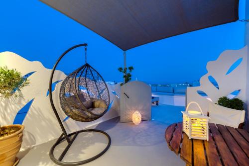 a room with a swing and a table and some plants at Pasithea Suites in Megalokhori