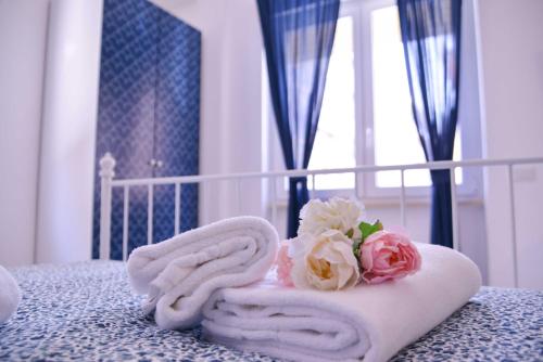 a towel on a bed with flowers on it at Vatican Mirò Holidays in Rome