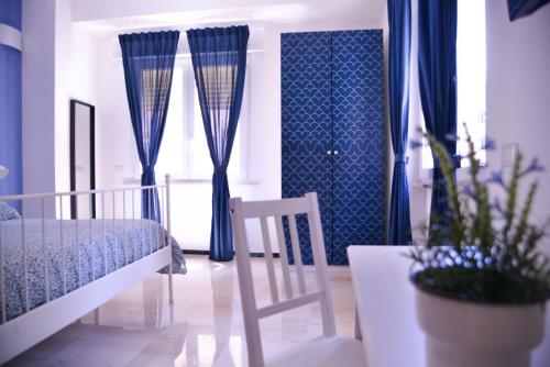 a bedroom with blue curtains and a bed and a plant at Vatican Mirò Holidays in Rome