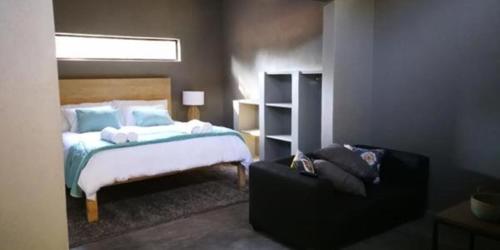a bedroom with a bed and a couch at Dream of Africa Bush Lodge in Marloth Park