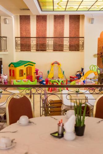 a dining room with tables and toys on shelves at Hotel Pella in Giannitsa