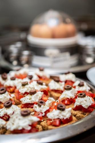 a pizza with toppings on a pan on a table at Hotel Pella in Giannitsa
