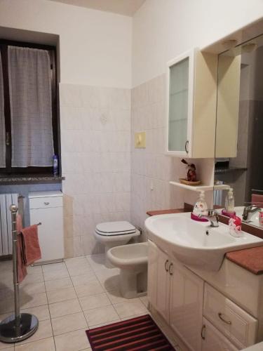 a bathroom with a white sink and a toilet at La casa di Ginger - Malpensa in Cardano al Campo
