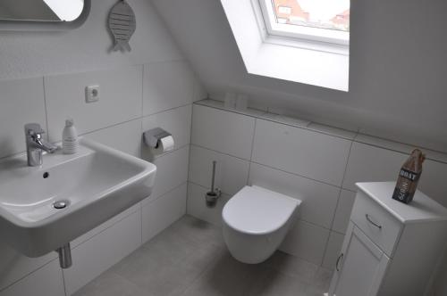 a white bathroom with a toilet and a sink at Haus Antonie in Dahme