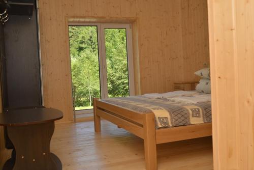 a bedroom with a bed and a window at Lisnyi in Mizhhirʼʼya