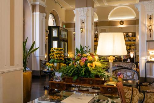 a lobby with a table with flowers on it at Hotel Bernini Palace in Florence