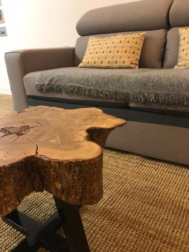 a tree stump coffee table in front of a couch at Porta 20 in Loulé