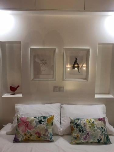 a bedroom with two pillows and two pictures on the wall at Porta 20 in Loulé