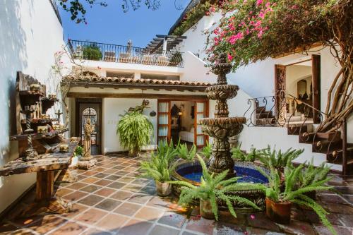 a courtyard of a house with a fountain and plants at Hacienda San Angel in Puerto Vallarta