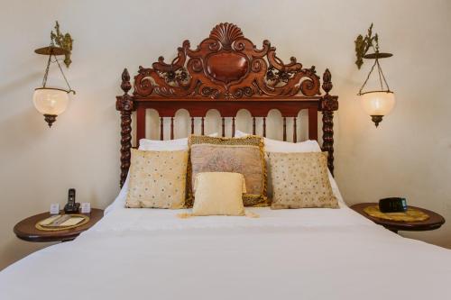 a bed with a wooden headboard and pillows at Hacienda San Angel in Puerto Vallarta