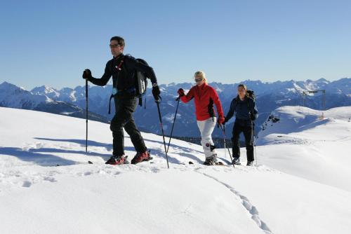 three people on skis on a snow covered mountain at Appartements Obergollerhof in Assling
