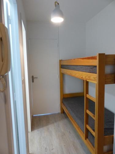 Cette chambre comprend 2 lits superposés et une porte. dans l'établissement Plage des Minimes PONANT 6 VUE MER, à La Rochelle