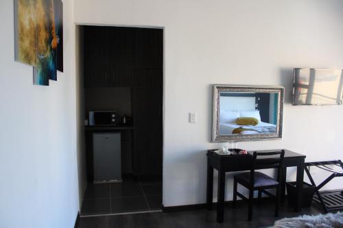 a dining room with a table and a mirror at Scenery Guest House in Kokstad
