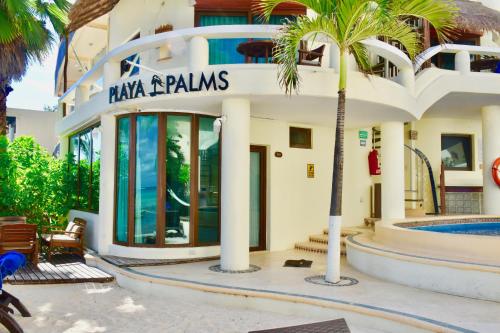a building with a palm tree in front of it at Playa Palms Beach Hotel in Playa del Carmen