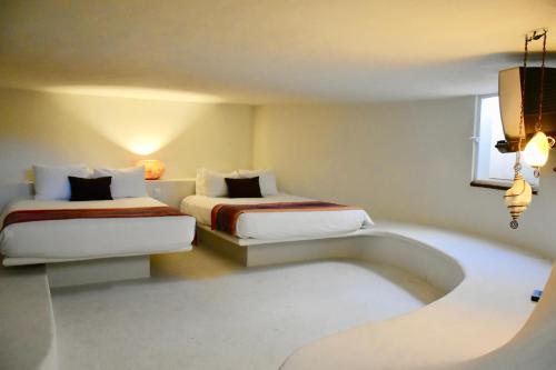 a hotel room with two beds and a window at Playa Palms Beach Hotel in Playa del Carmen