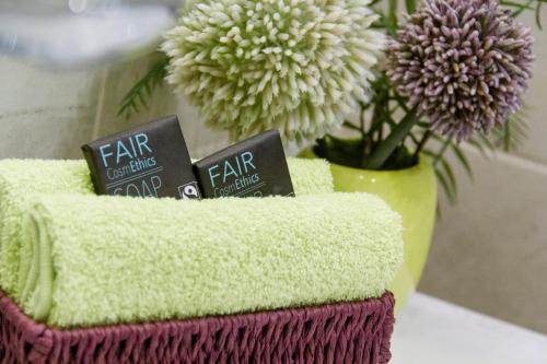 a towel holder with two tar signs on it with flowers at College Garden Hotel in Bad Vöslau
