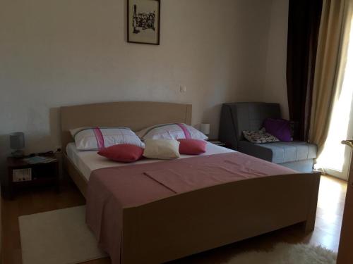 een slaapkamer met een bed en een stoel bij Barać in Kaštela