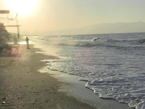 a person riding a surfboard on the beach at Evangelos Apartments in Platanias