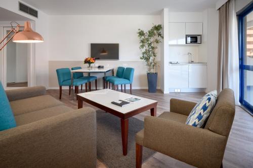 a living room with a couch and a table and chairs at Hotel Pestana Cascais Ocean & Conference Aparthotel in Cascais