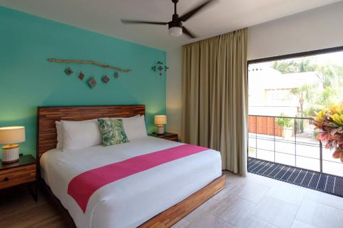 a bedroom with a bed and a large window at San Trópico Boutique Hotel & Peaceful Escape in Puerto Vallarta