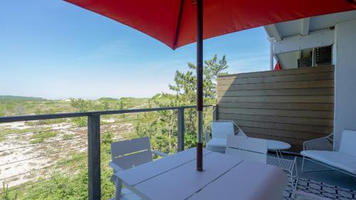 a balcony with a table and chairs and an umbrella at Driftwood Resort on the Ocean in Montauk