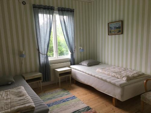 Habitación pequeña con cama y ventana en STF Regnagården Hostel, en Regna